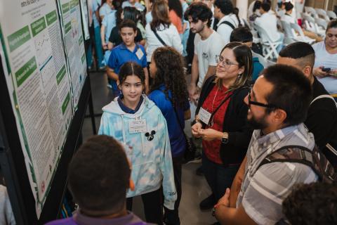 Data Jam students present their research poster to their scientific mentor.