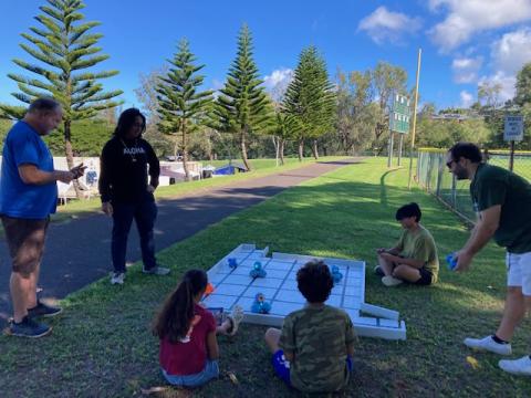 students coding dash robots in a park