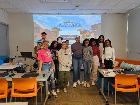 A group of students in Puerto Rico posing in front a screen showing the Fornite interface.