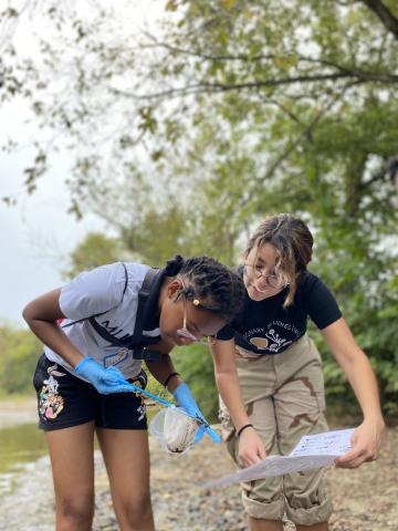 College near-peer mentor assists middle school student with identifying macro invertebrates found in a local watershed