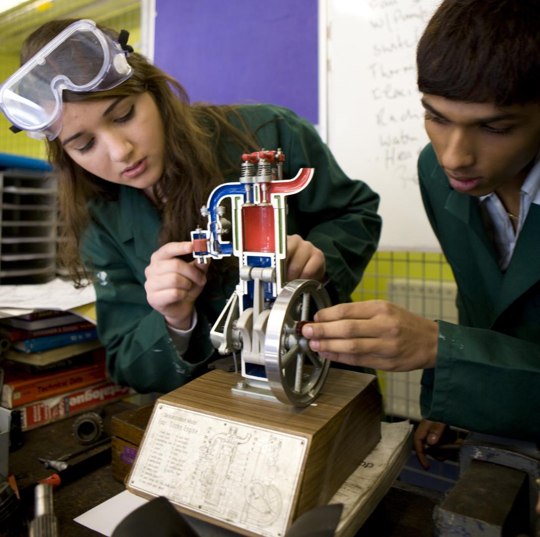 Two students examine a model.